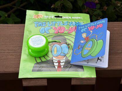 a photo of the Little Book Of Yo-Yo comic book. The photo also shows the transaxle yo-yo and the green plastic bag that everything comes in.