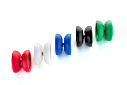 5 yo-yos on a white surface. The yo-yos are on their side, so you can see their profile. It is a wide butterfly shape with an organic profile. The yo-yos are Bolt yo-yos in each colorway. Black, red, blud, white, and green.