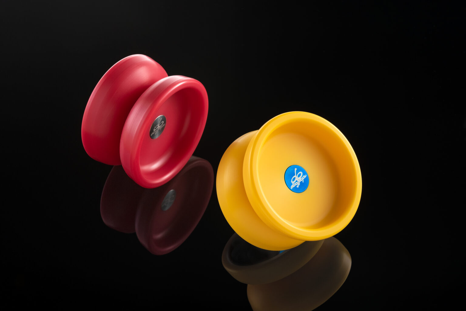 Two Thing Yo-yos, one is yellow and the other is red. They both appear to be floating in black space.