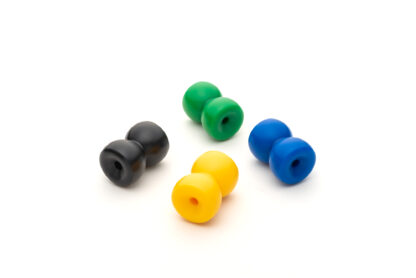 A photo of four counterweights in different colors. These are made from machined plastic and look like little yo-yos (with a hole running through them so you can thread string through them).